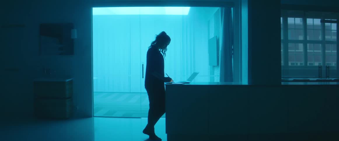 A woman is using a laptop in the dark room