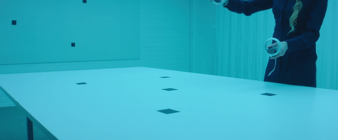 A woman is waving virtual reality controllers around