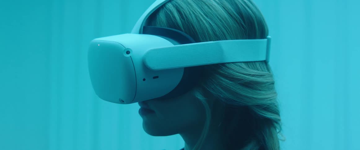 A woman in a room with a virtual reality headset with a wall in the background