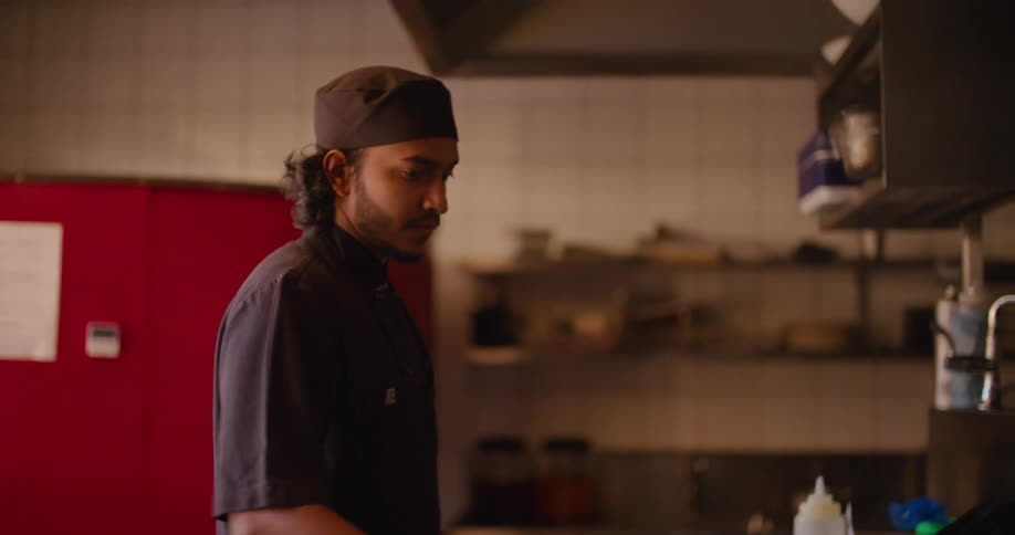 Chef flambeing food on a pan over a fire in a restaurant kitchen