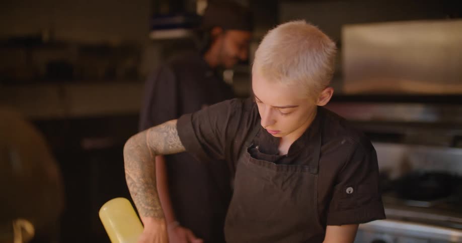Chef plating a dish in the kitchen of a restaurant