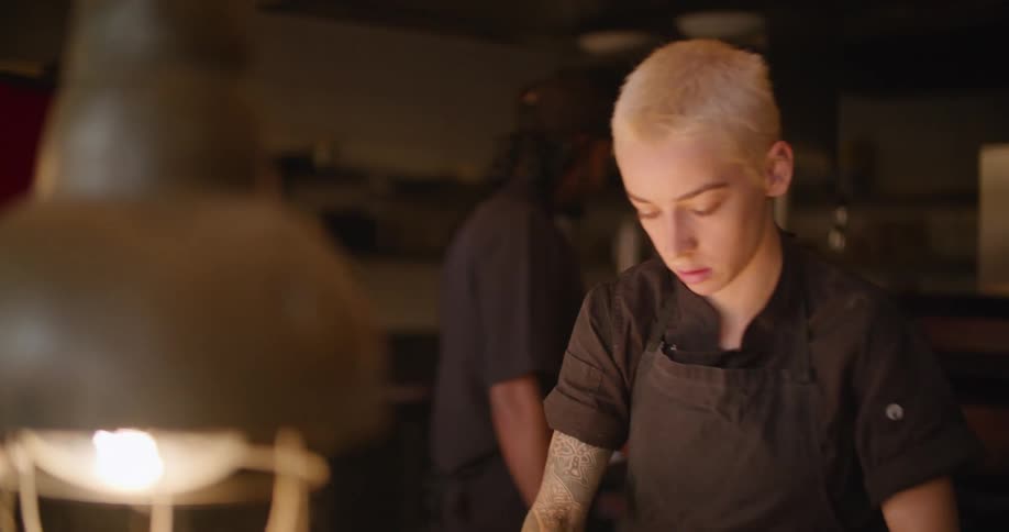 A young female chef peels an onion