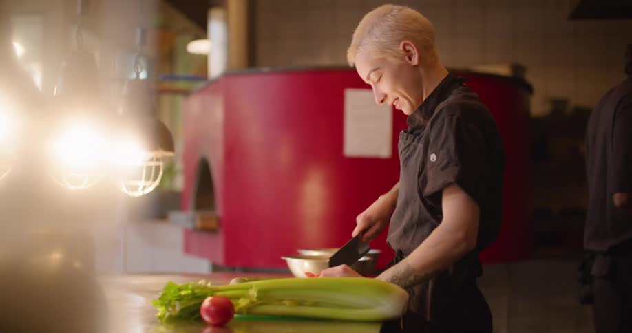 A chef cuts vegetables in a restaurant