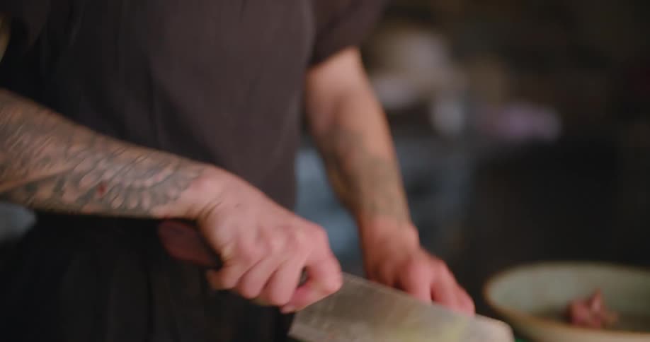 A restaurant chef cuts a piece of steak into slices