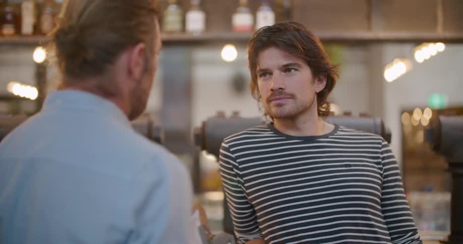 Two men talk together in a restaurant