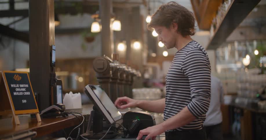 An employee in a restaurant working on a computer