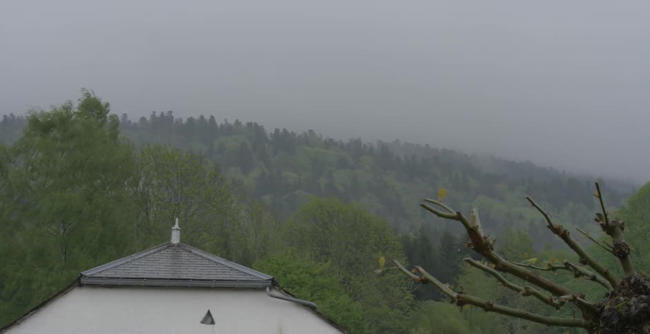 Time lapse of weather moving across a tree covered hill