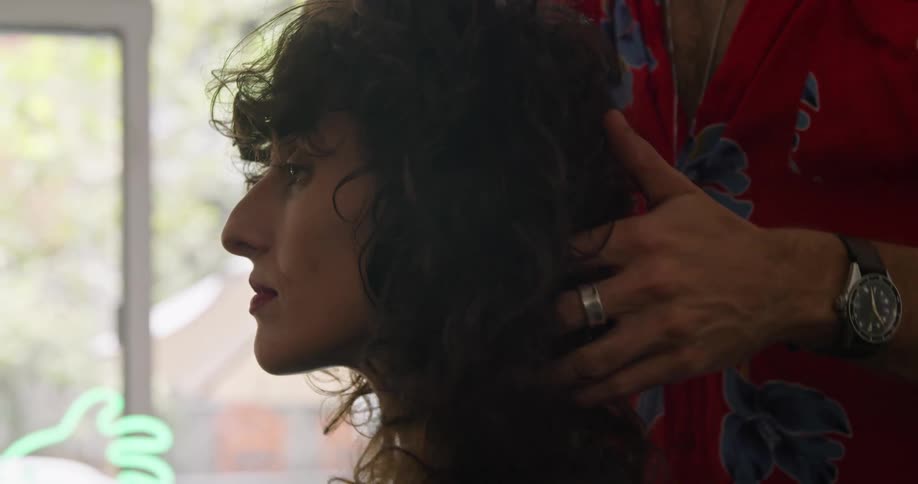 A man moves a womans hair around as he prepares to style it