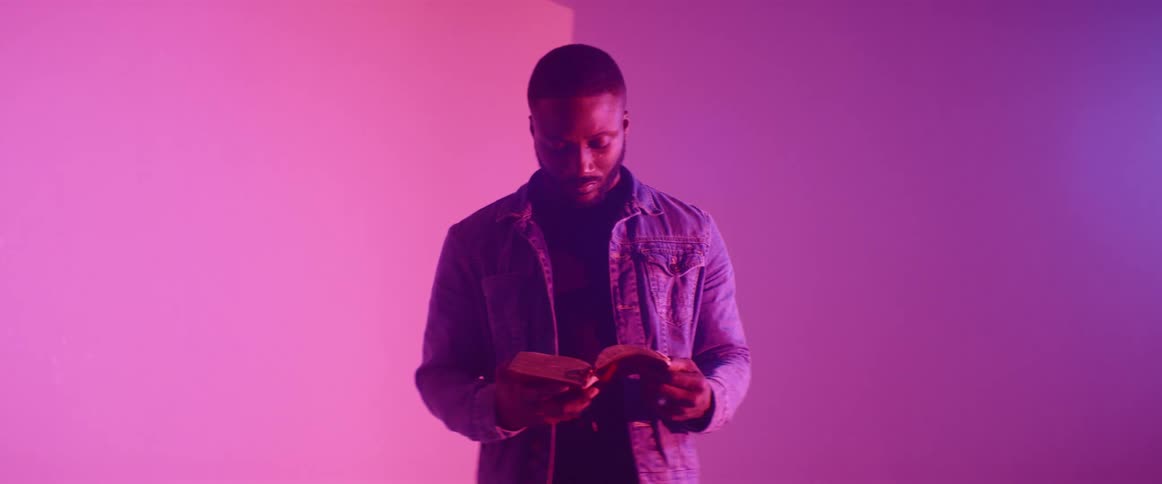 A man is reading a book by the bright lights