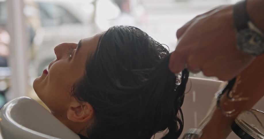 A woman is getting her hair washed at the barbershop