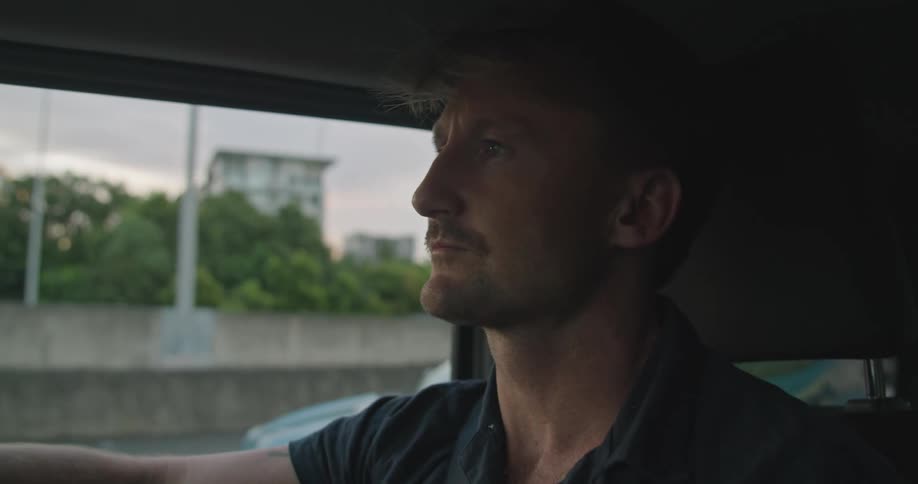 A man is driving and looks at his watch