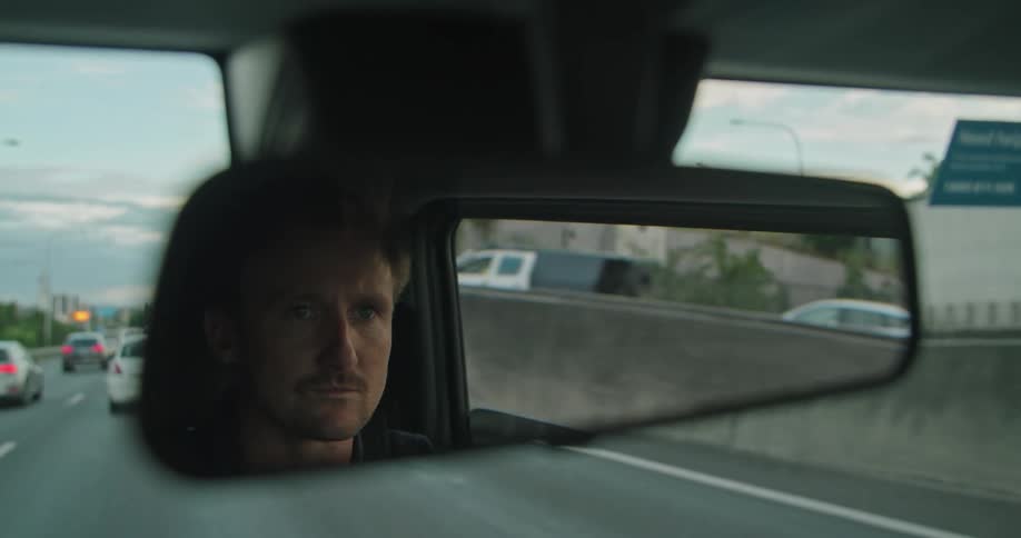 A man drives in a vehicle on the highway