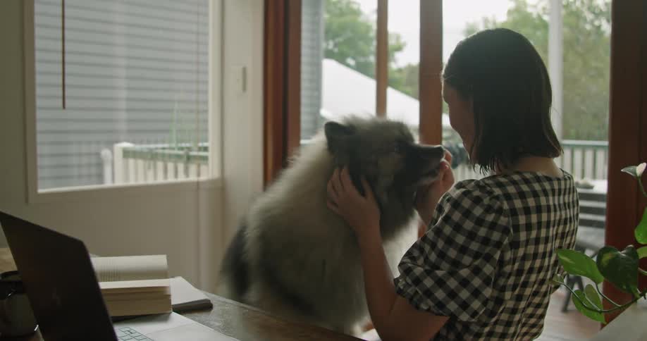 Young woman gives her dog a treat