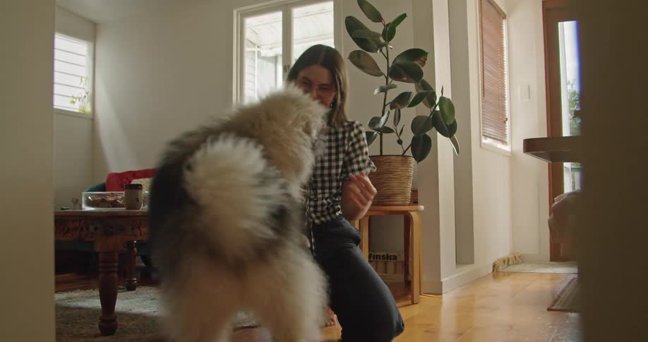 A female caucasian is petting and hugging her dog in a living room