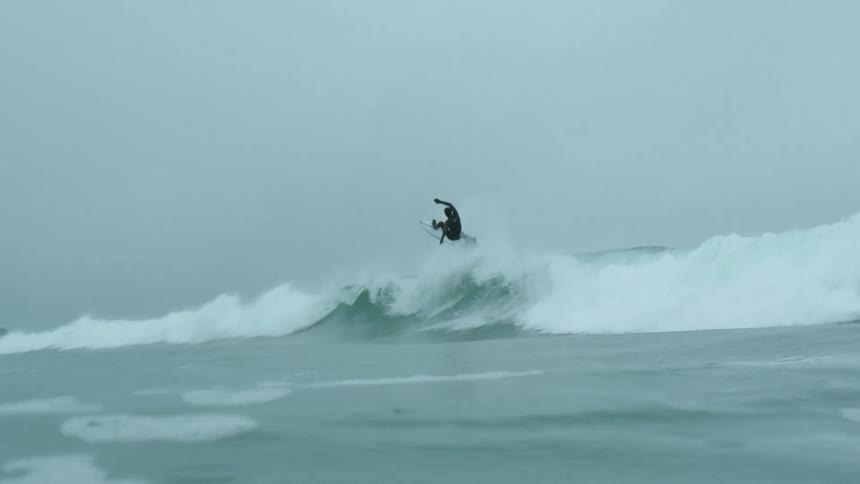 Surfer rides a huge wave and goes underwater