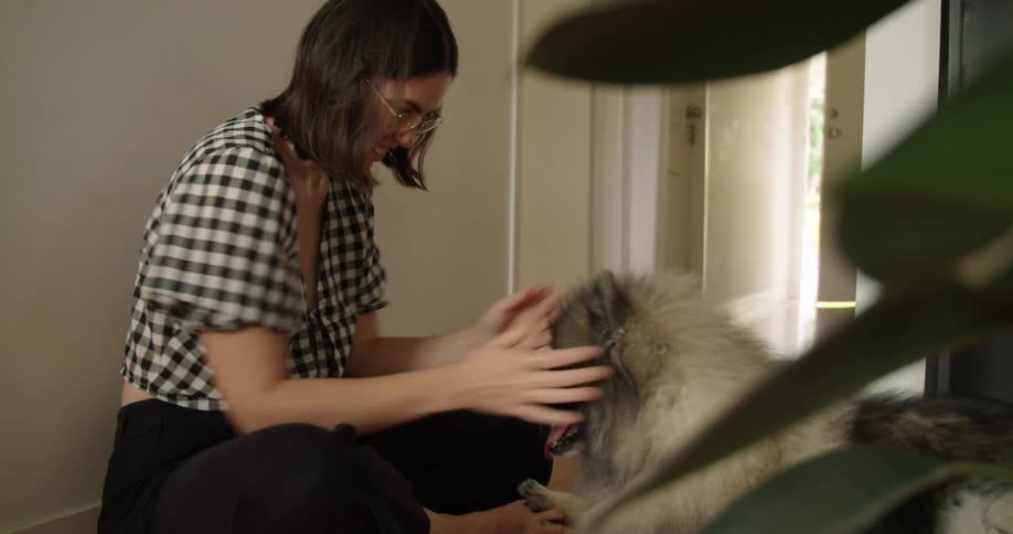 A woman is playing with her dog at home