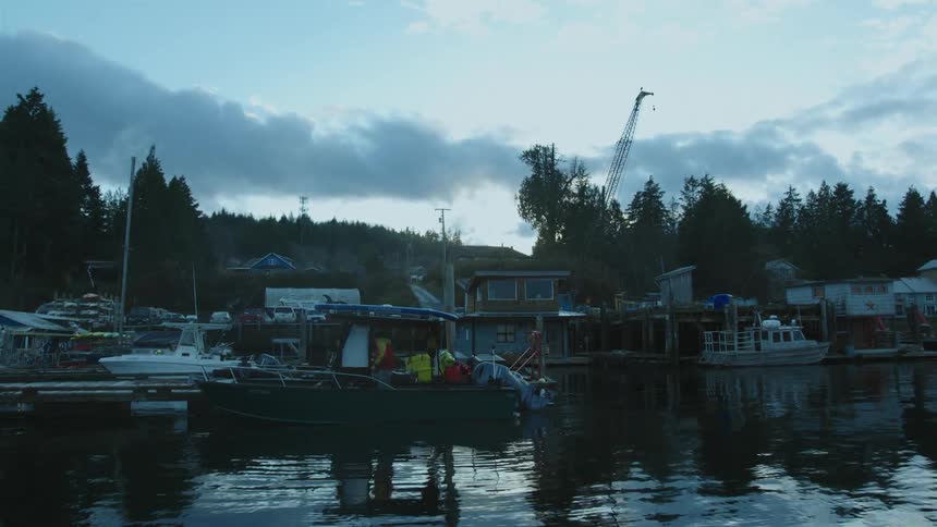 A man is working on the boat by the pier