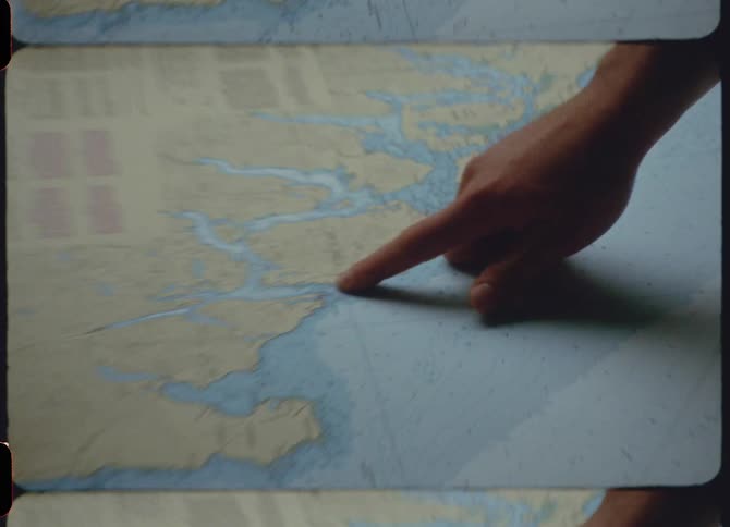 Film footage of a person pointing at a map