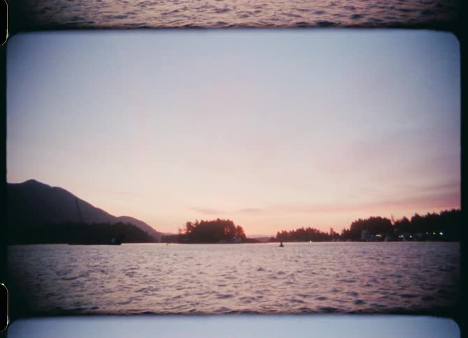 A lake with rippling water with trees the sky and clouds in the background
