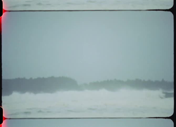 Strong waves crashing on the coast caught on vintage film