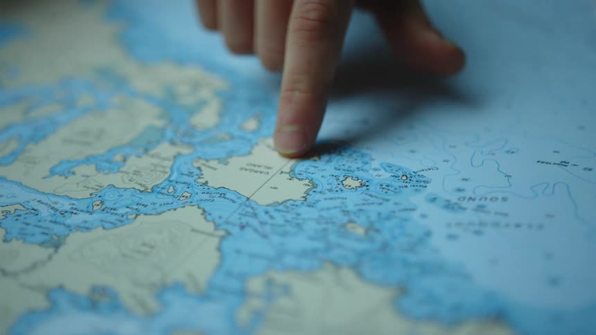 A person pointing with his finger iver a map