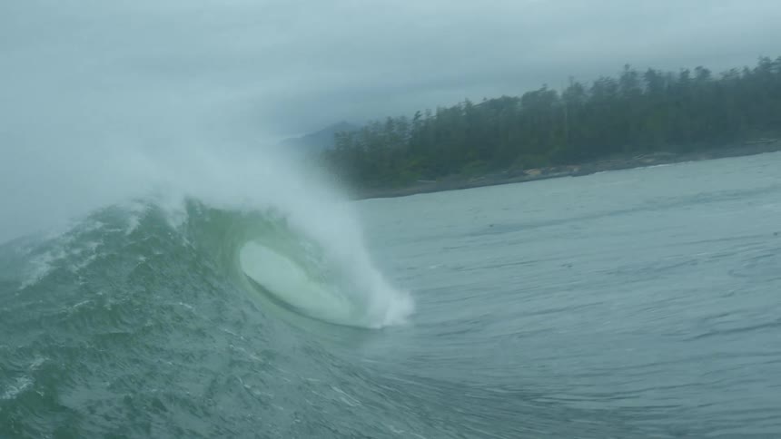Huge wave rolls in splashing on rough water
