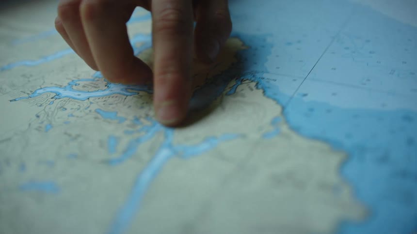 A person points to locations on a map