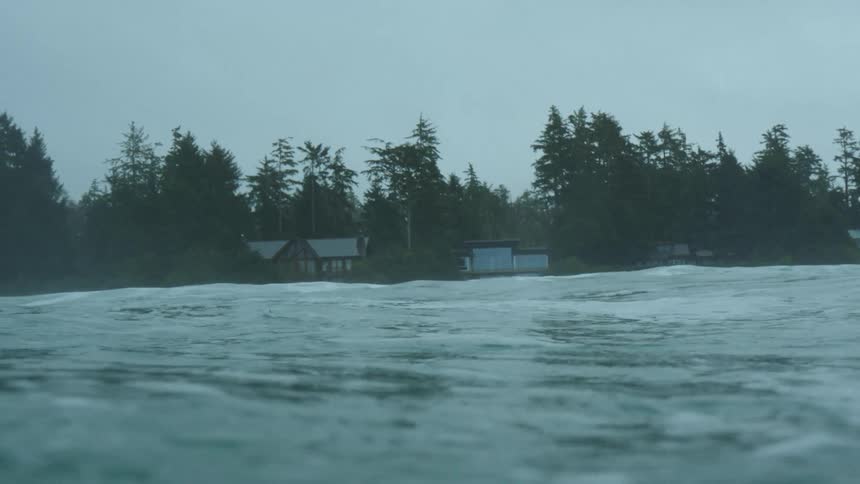 Waves roller in a river that runs along a neighborhood
