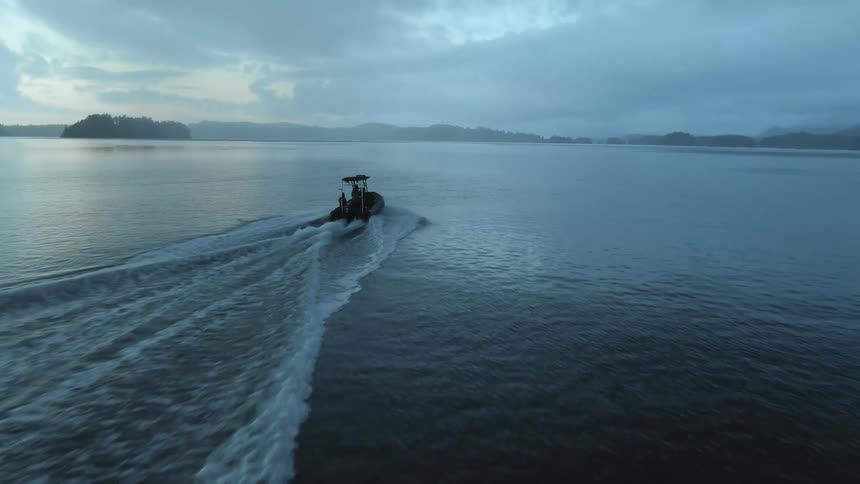 Speedboat travels across the water fast at dusk
