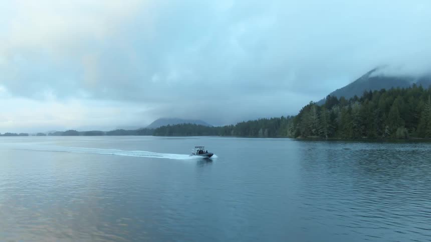 Speedboat travels across water along a coast on a cloudy day