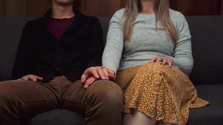 Young couple sitting together hold hands