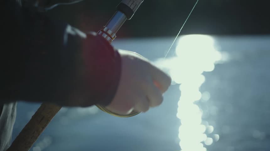 A person is reeling in their fishing pole