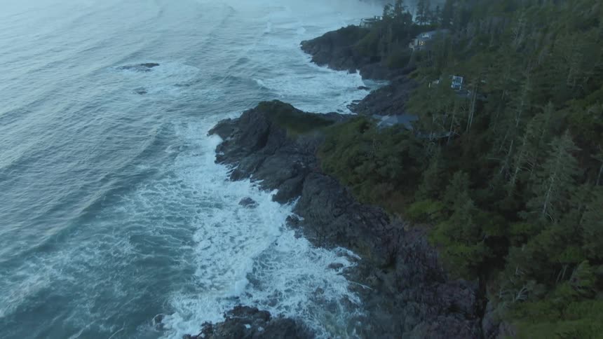Aerial view of ocean waves crashing on a rocky coast