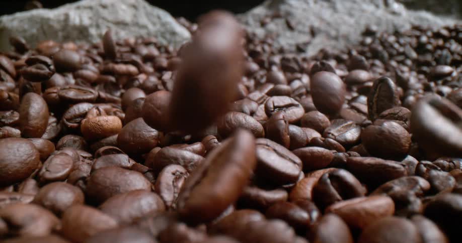 Coffee beans tumbling into a pile