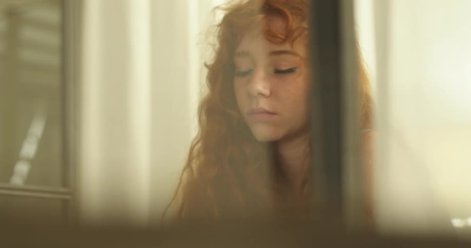A girl inside is tilting her head to the side