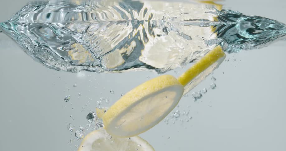 Line slices falling into water with bubbles with a white background