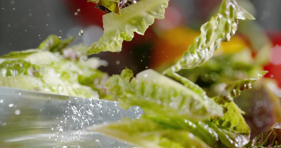 A close up of a knife cutting through lettuce