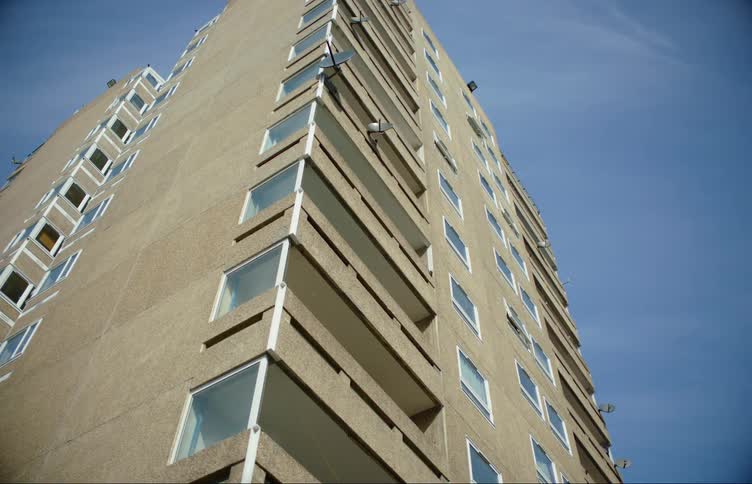 Identical balconies run down the front of a tall apartment building