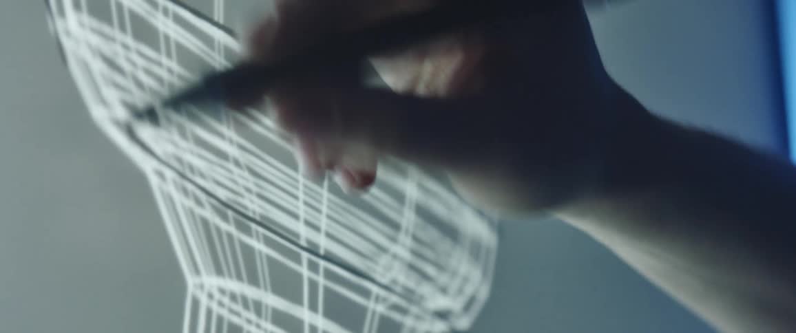 A person in a room with a marker drawing on a screen
