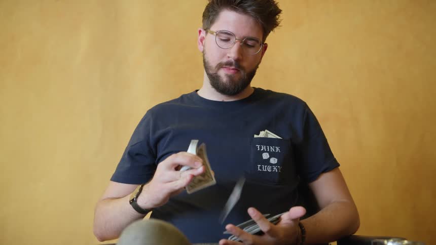 Man releases a deck of cards one by one into his other hand
