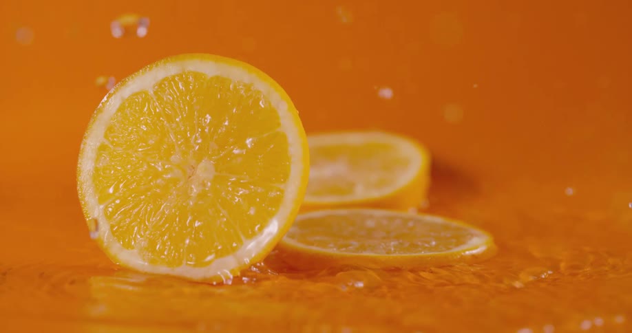 A view of oranges falling into water in slow motion