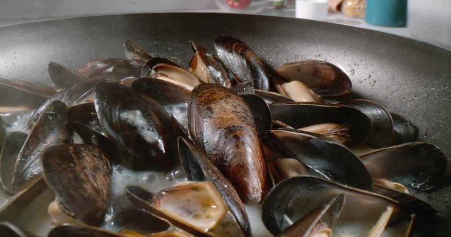Seafood simmering in a pan on a stovetop
