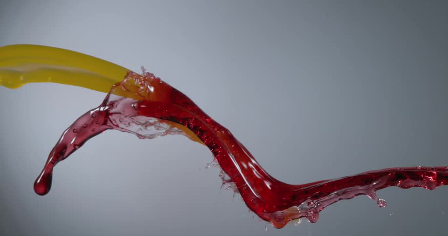 Two streams of red and yellow liquid splashing
