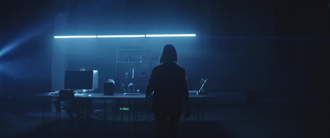 Woman enters a futuristic office and opens a folder placed over a desk