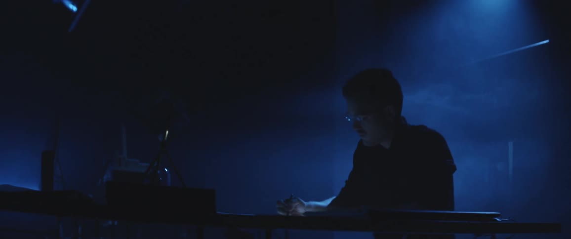 A man is sitting at a desk at night