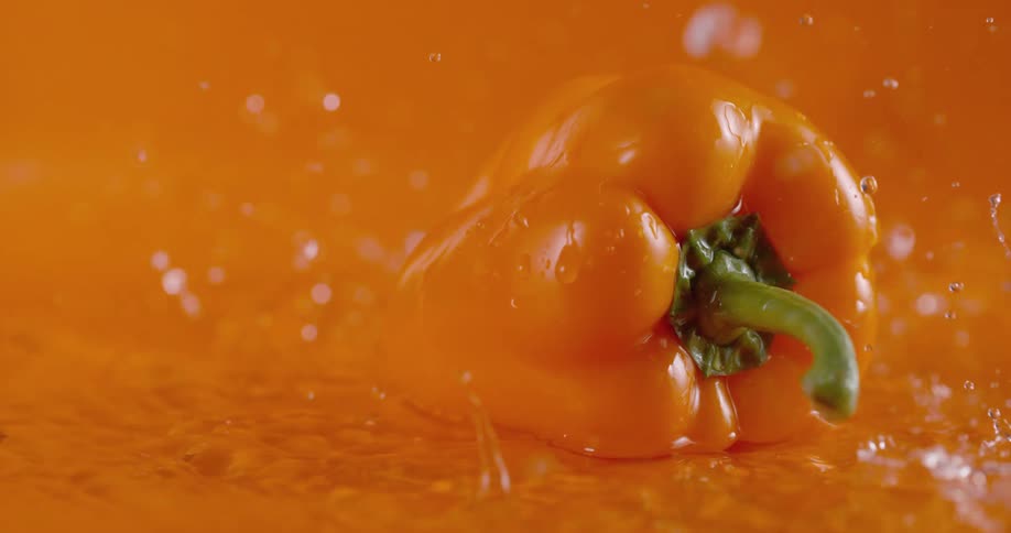 Water pours on a orange pepper