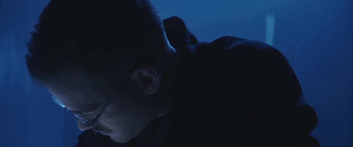 A man is looking down in the dark room