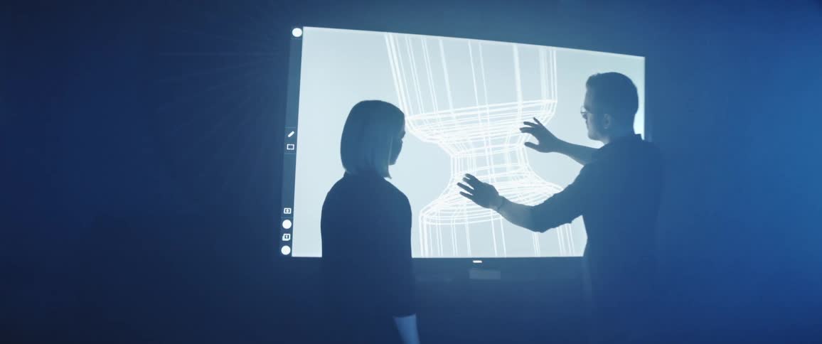 Designers working on an interactive screen inside a futuristic office