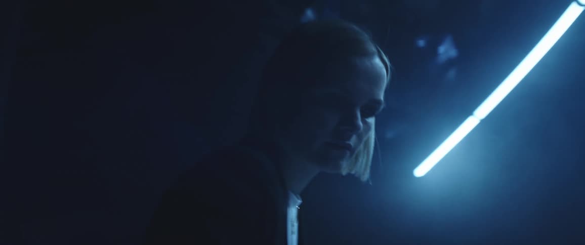 Woman working on a dark office under blue lights