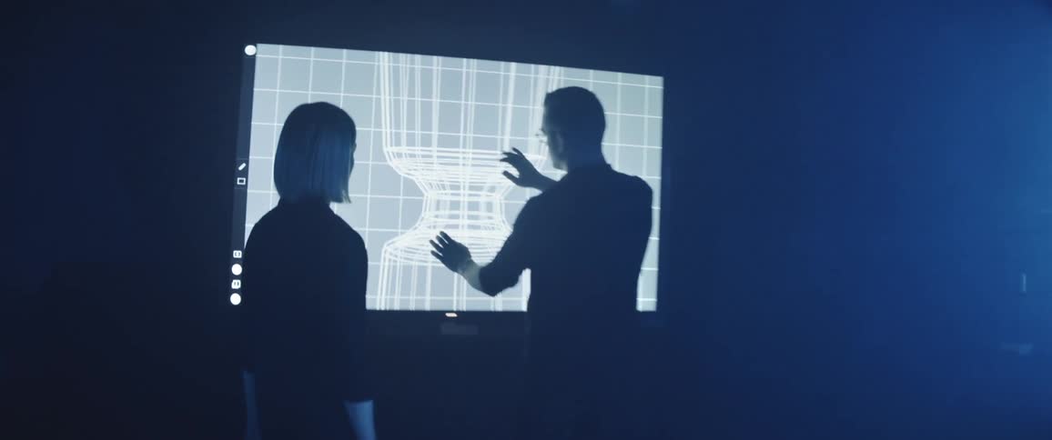 A man shows a woman a diagram on the screen